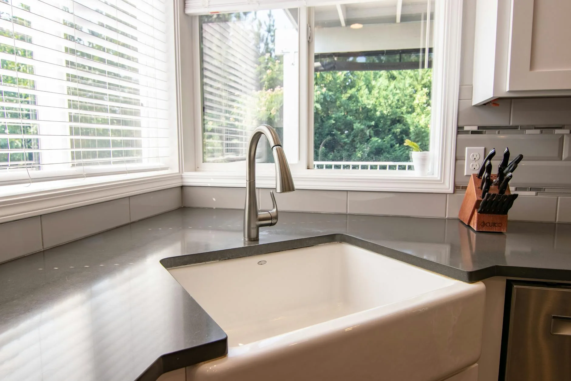 Stylish kitchen sink with stainless steel faucet and knife block by a bright window.